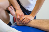 Physiotherapist massaging an injured ankle