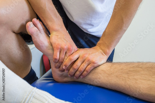 Physiotherapist massaging an injured ankle