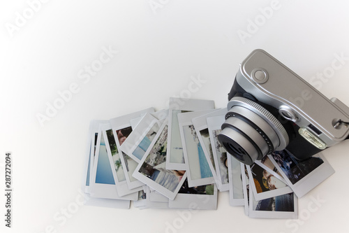 Cámara con objetivo desplegado y fotografías instantáneas