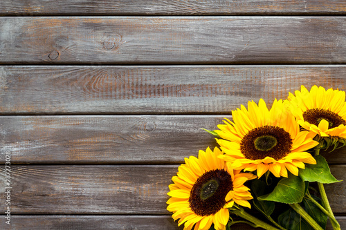 Beautiful yellow sunflowers frame on wooden background top view mock-up