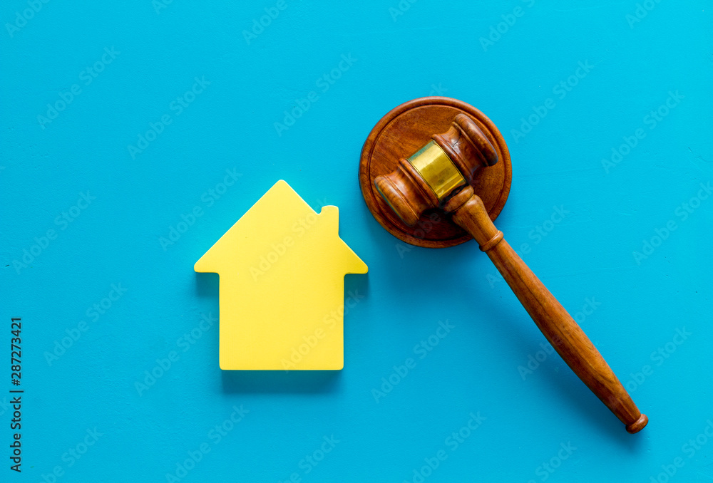 Inscribed gavel, house figure for inheritance concept on blue background top view Inscribed gavel, house figure for inheritance concept on blue background top view