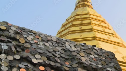 A hand held, low angle, close up shot of a roof covered with silver and copper coins. photo