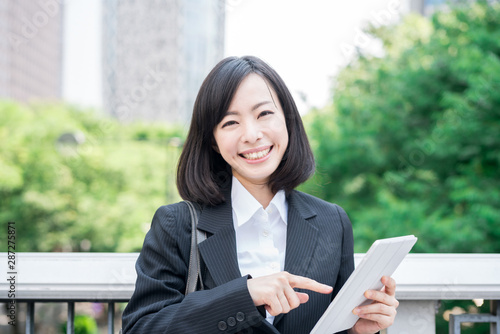 Young business woman using tablet computer outside