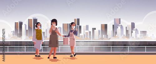 women wearing face masks environmental industrial smog dust toxic air pollution virus protection concept girls walking outdoor city building cityscape skyline background full length horizontal