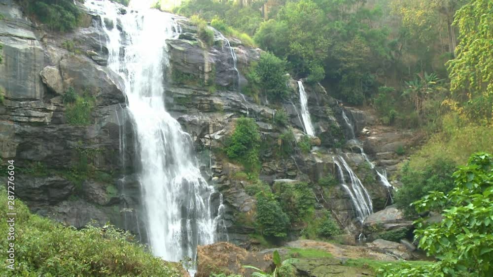 A hand held, panning, wide shot of an amazing view of a tall waterfall. A hand held, panning, wide shot of an amazing view of a tall waterfall.