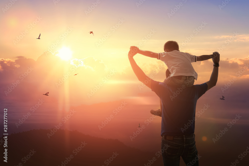 Son riding back father with outdoors on background sunset. Father holiday