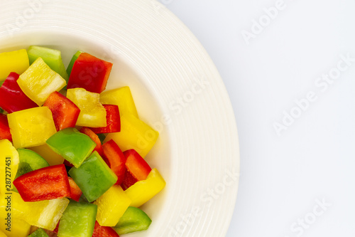 Sliced bell pepper on single white ceramic bowl over white background.
