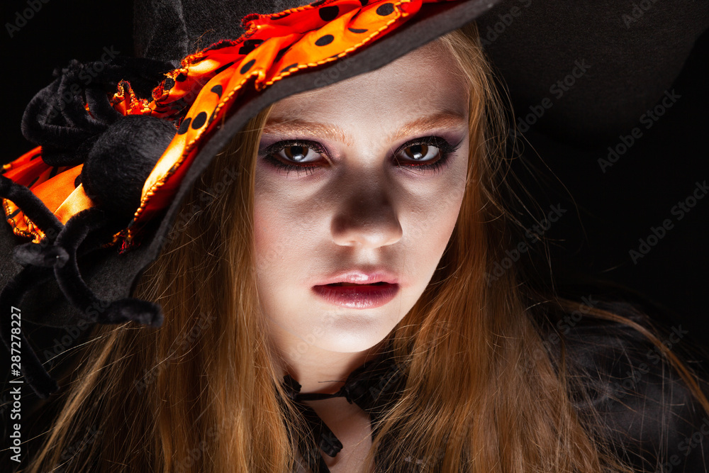 Halloween. Witch with a spider on his hat on black background. Beautiful young surprised woman in witches hat and costume holding. Wide Halloween party art design. Copy-paste. Witch craft concept Halloween. Witch with a spider on his hat on black background. Beautiful young surprised woman in witches hat and costume holding. Wide Halloween party art design. Copy-paste. Witch craft concept