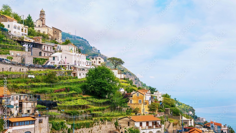 The small, quaint Italian village of Furore, with picturesque small vineyards and gardens built on a steep terraced hillside overlooking the Mediterranean Sea on the Amalfi Coast.