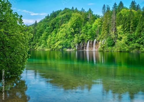 A beautiful summer nature scene in the forest  with waterfalls and trees reflected in a calm lake. Plitvice Lakes National Park  Croatia.