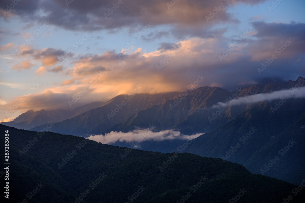 Mountain ranges in the clouds at sunset.