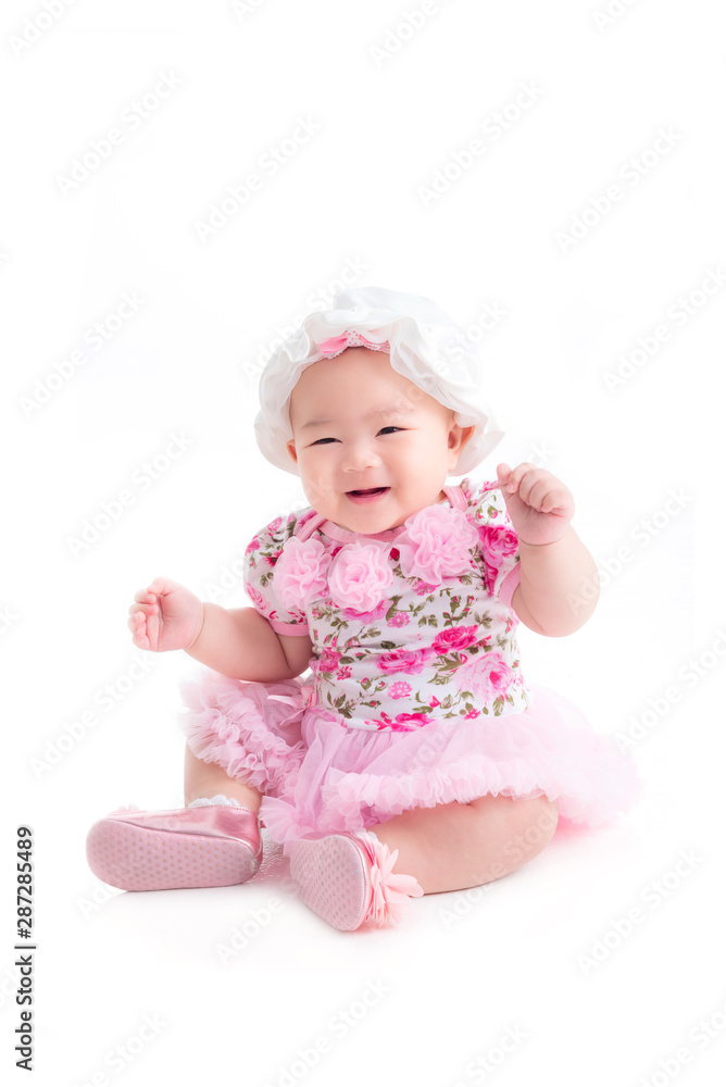 Full length of little asian baby girl in sweet pink dress sitting isolated over white background Full length of little asian baby girl in sweet pink dress sitting isolated over white background