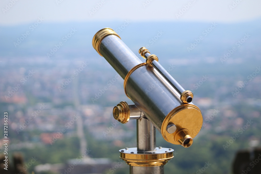 telescope in front of a cityscape