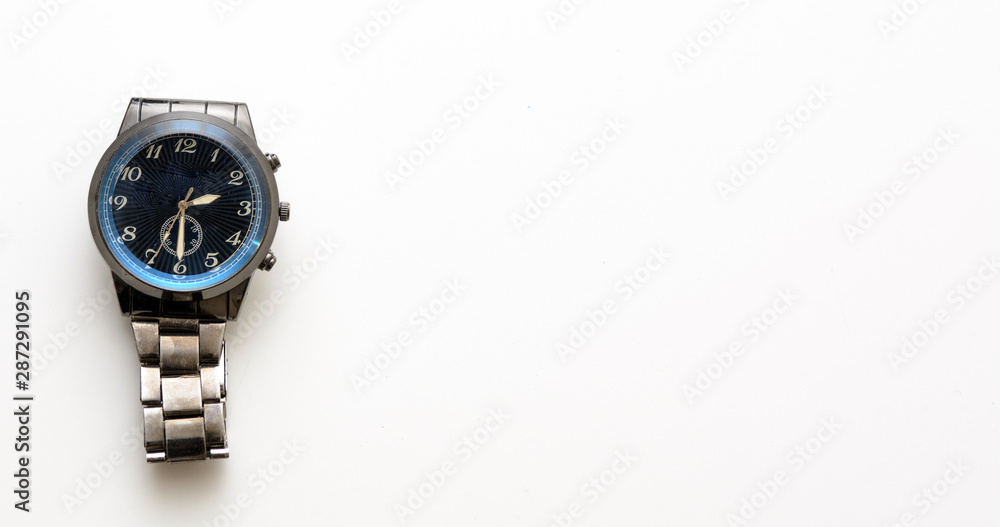 A wristwatch is lying on a white background. The concept is not to waste time. Time to work. Copy space A wristwatch is lying on a white background. The concept is not to waste time. Time to work. Copy space