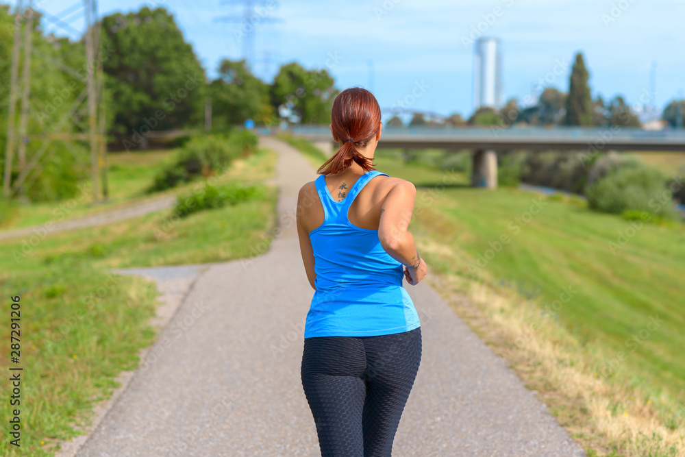 Fit woman jogging away from the camera