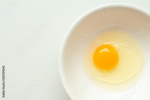Fresh raw egg in bowl on white background.