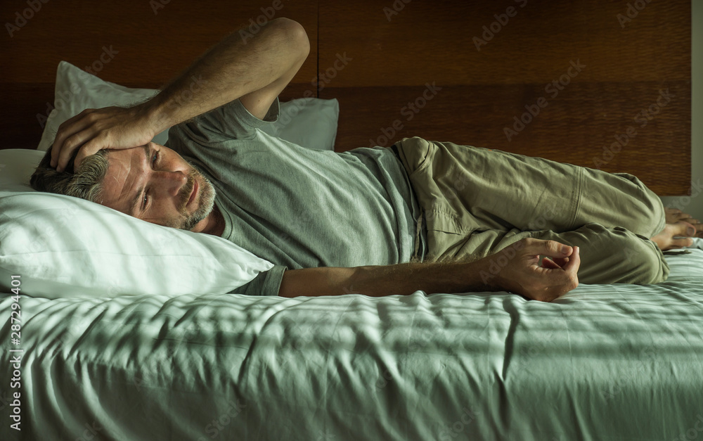 young attractive sad and depressed man crying helpless on bed at home bedroom feeling overwhelmed and desperate suffering depression problem young attractive sad and depressed man crying helpless on bed at home bedroom feeling overwhelmed and desperate suffering depression problem