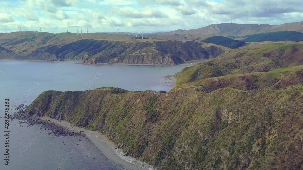 Aerial view over coastal hills in Wellington, New Zealand approaching wind farm Aerial view over coastal hills in Wellington, New Zealand approaching wind farm