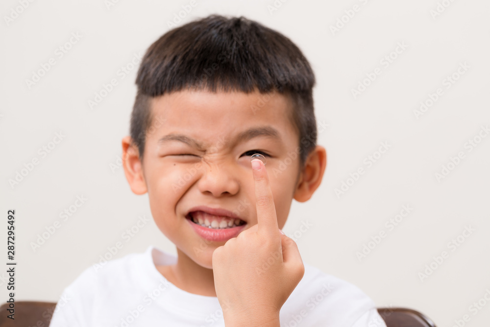 Kid hold with a contact lens with a smile Kid hold with a contact lens with a smile