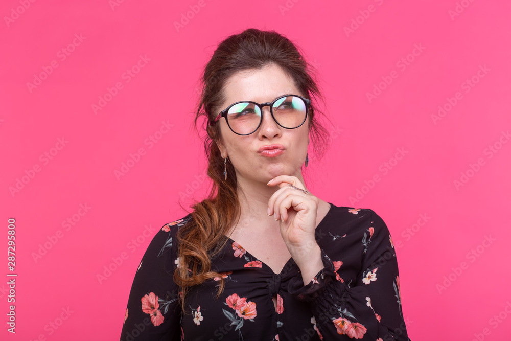 Business woman and student concept - Beautiful smart thoughtful girl looking up over pink background Business woman and student concept - Beautiful smart thoughtful girl looking up over pink background