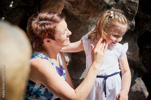 Beautiful mother and pretty small girl on stones