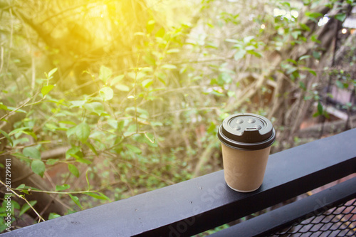 Blur background nature landscape panorama view from railing panel inside shopping mall with brown coffee recycle paper cup. Ray by sunlight