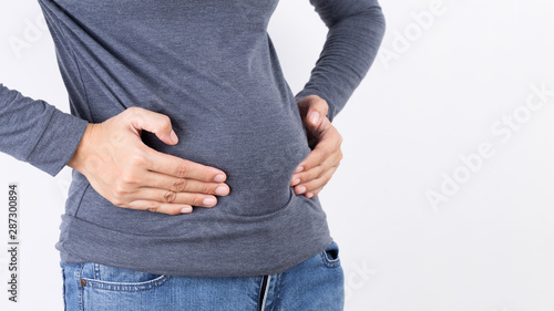 Bild auf Leinwand Woman hand holding her own belly fat and cellulite on white background