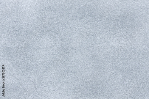 Background of light gray suede fabric closeup. Velvet matt texture of silver nubuck textile