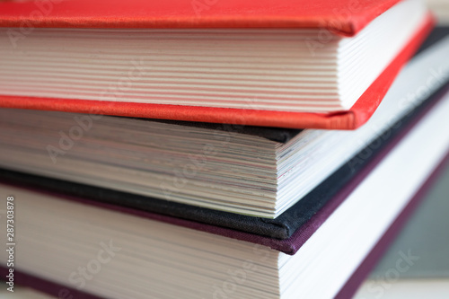 Close-up of book stack. Several colorful books with selective focus