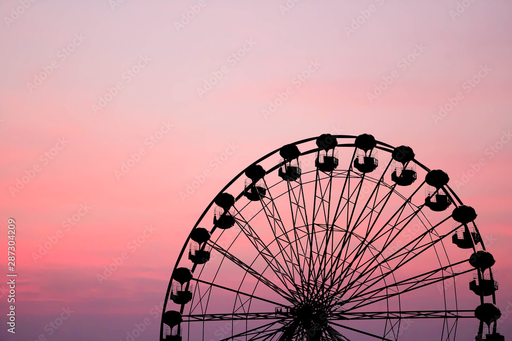 silhouette of ferris wheel on sunset background