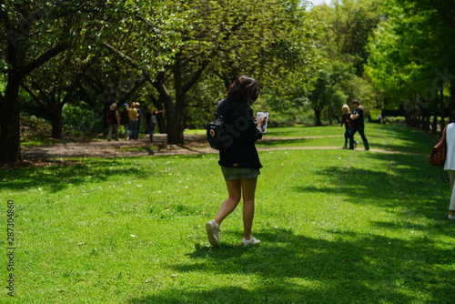 Girl walking on the park reading