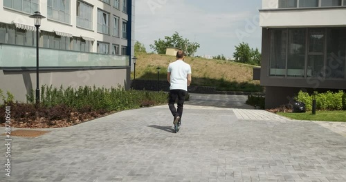 Walking on scooter in sunny weather in new area city, carefree pastime, day off