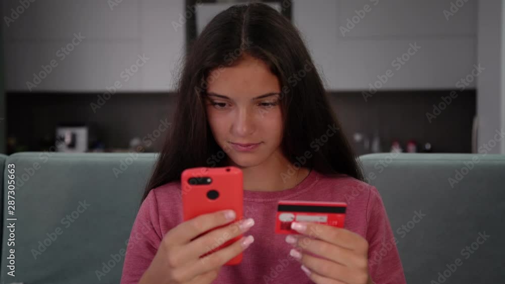 young pretty woman with manicure holds credit card and inputs data typing on modern smartphone close view young pretty woman with manicure holds credit card and inputs data typing on modern smartphone close view