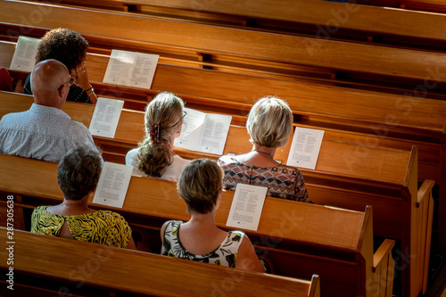 Foto Poeple singing worship songs at wooden bench in church with soft sun light