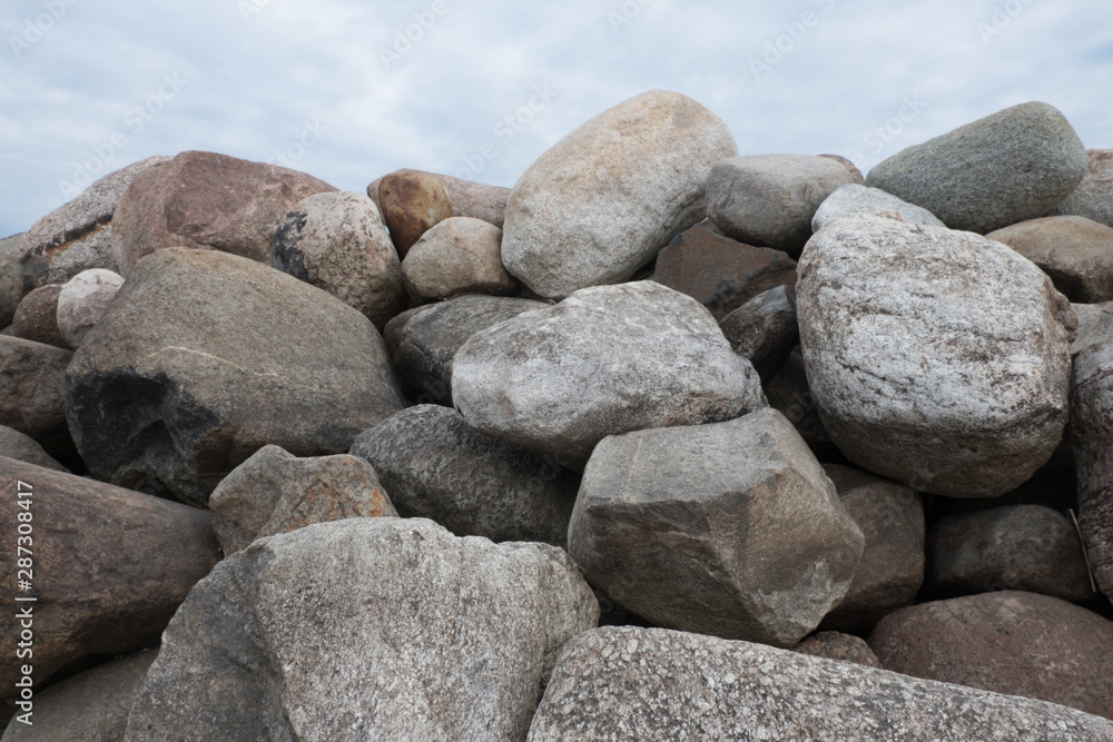 Retaining wall made of stones, boulders. Stone of volcanic rocks, granite, basalt, gabro. Bank protection on the sea beach. Protection of the coast from destruction by waves. Waterworks. Retaining wall made of stones, boulders. Stone of volcanic rocks, granite, basalt, gabro. Bank protection on the sea beach. Protection of the coast from destruction by waves. Waterworks.