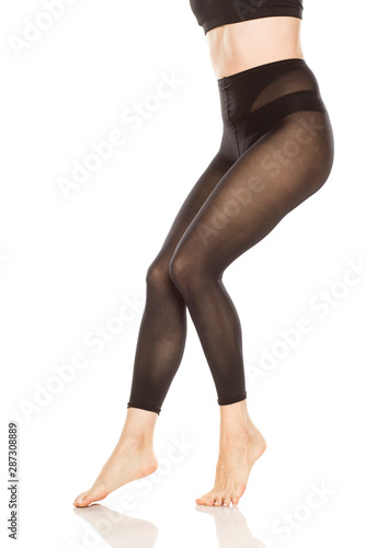 Young woman's legs with nylon tights on white background