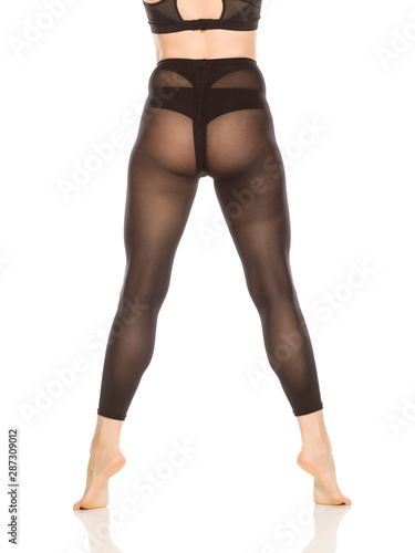 Back view of young woman's legs with nylon tights on white background