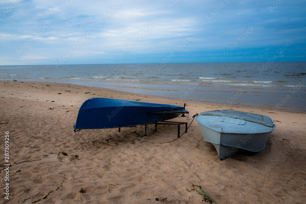 Sea view on a cloudy day. Fishing boats on the shore. Sand beach. Summer. Evening, cloudy. Sea view on a cloudy day. Fishing boats on the shore. Sand beach. Summer. Evening, cloudy.