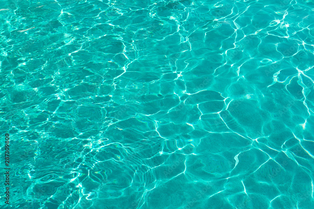 Water ripples on blue tiled swimming pool background. View from above
