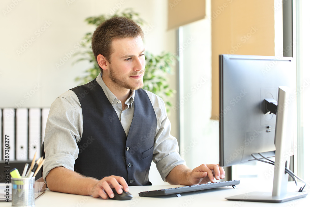 Serious executive browsing computer content at office Serious executive browsing computer content at office