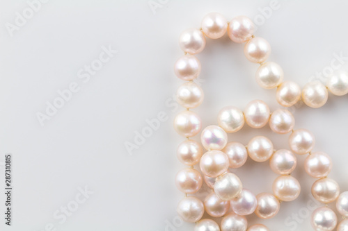 Pearl necklace with real pink pearls isolated on white background - top view photo