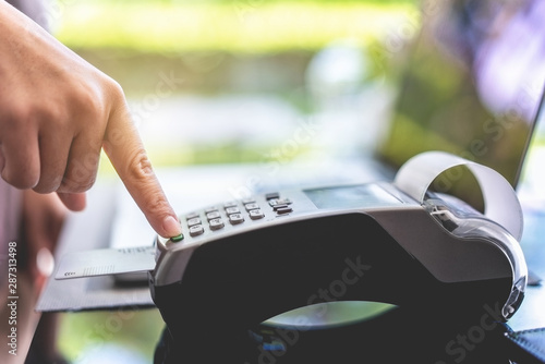 Customer using credit card for payment at coffee shop.