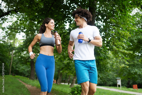 Beautiful couple jogging in nature living healthy