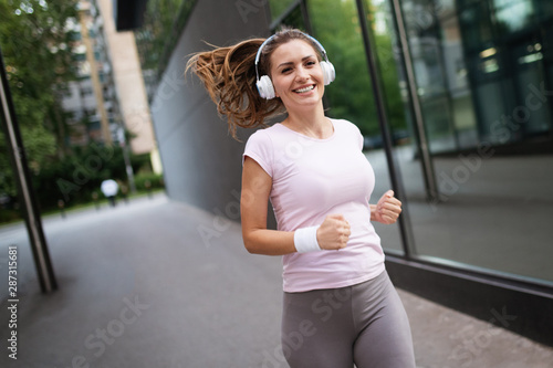 Beautiful sporty fit woman running and relaxing in city