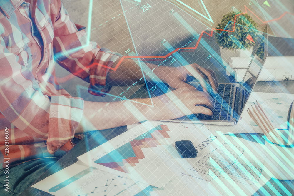 Double exposure of stock graph with businessman typing on computer in office on background. Concept of hard work. Double exposure of stock graph with businessman typing on computer in office on background. Concept of hard work.