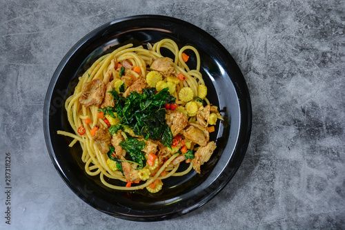 Hot and spicy chicken spaghetti, topping with crispy sweet basil and sliced baby corn