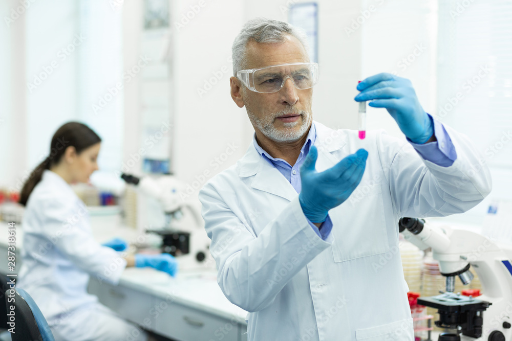 Serious mature researcher working in modern laboratory Serious mature researcher working in modern laboratory
