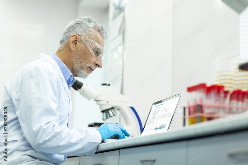 Positive delighted lab worker staring at computer Positive delighted lab worker staring at computer