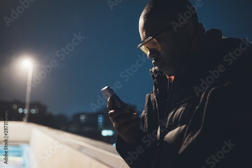 young african man outdoor using smartphone