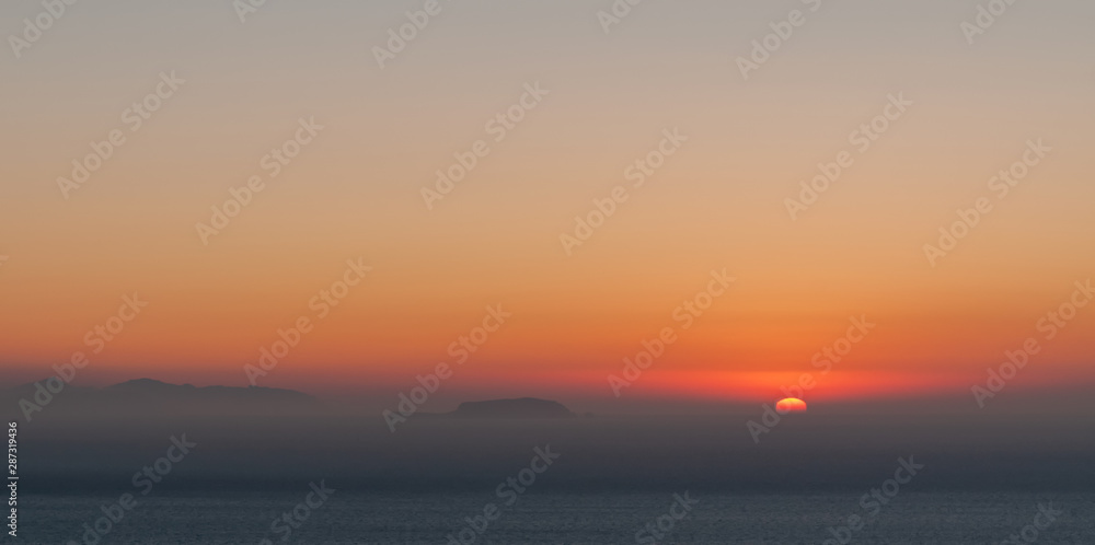 Blurred sunrise with thin mist in the Aegaean sea, Santorini island. Blurred sunrise with thin mist in the Aegaean sea, Santorini island.